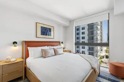 a bedroom with a bed and a large window at Central Downtown Miami Condo Featuring Rooftop Pool in Miami