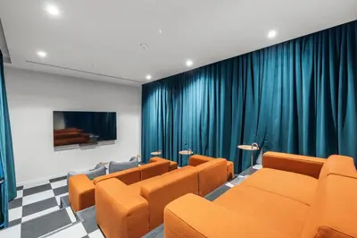 a waiting room with orange chairs and blue curtains at Central Downtown Miami Condo Featuring Rooftop Pool in Miami
