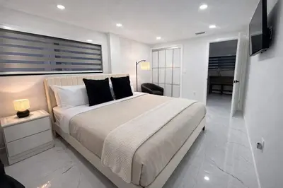 a white bedroom with a large bed and a television at Luxury 2BR Miami Retreat King Suite Free Parking in Miami