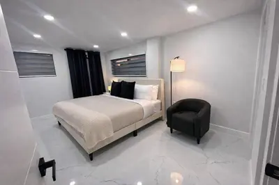 a bedroom with a bed and a chair in it at Luxury 2BR Miami Retreat King Suite Free Parking in Miami