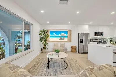 a living room with a table and a kitchen at Tropical Bliss 15 Min to Beach in Plantation