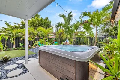 a hot tub in a garden with palm trees at Tropical Bliss 15 Min to Beach in Plantation