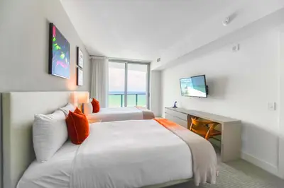 a hotel room with two beds and a television at Oceanfront Escape - Rooftop Pool & Beach Access in Hollywood