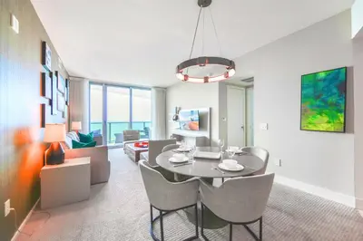 a dining room and living room with a table and chairs at Oceanfront Escape - Rooftop Pool & Beach Access in Hollywood