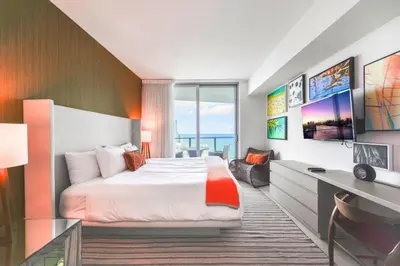 a hotel room with a bed and a desk and a window at Ocean Views Plus Beachside & Roofpool in Hollywood