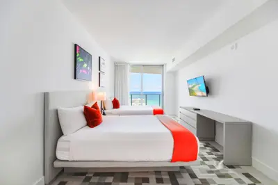 a bedroom with two beds and a desk at Ocean Views Plus Beachside & Roofpool in Hollywood