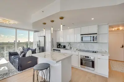 a kitchen with white cabinets and a living room at Elegant Condo with Stunning Views in Dtwn Hollywood in Hollywood