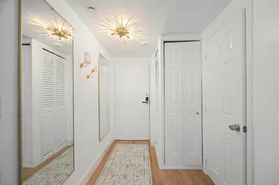 a hallway with white walls and white doors and a rug at Elegant Condo with Stunning Views in Dtwn Hollywood in Hollywood