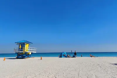 a beach with a life guard tower and people on the beach at Elegant Condo with Stunning Views in Dtwn Hollywood in Hollywood