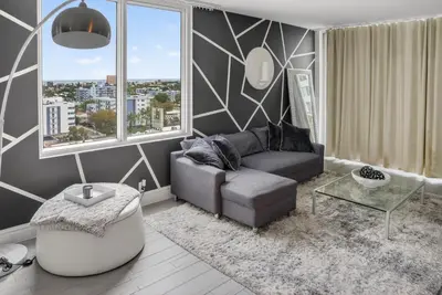 a living room with a couch and a large window at Mondrian in Miami Beach