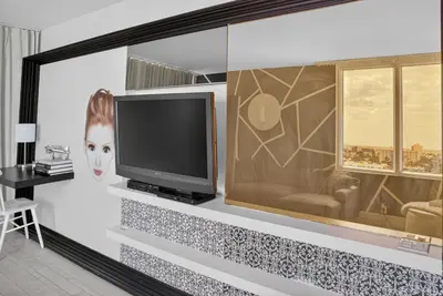 a living room with a television on a wall at Mondrian in Miami Beach