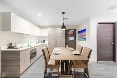 a kitchen with a wooden table and chairs in a room at Ocean View Stay with Rooftop Pool Near the Beach in Hollywood