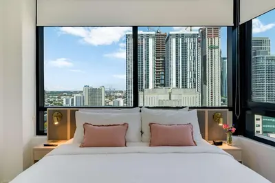 a bedroom with a large bed with a large window at Sky Corner Residence- Pool Parking Amenities in Miami