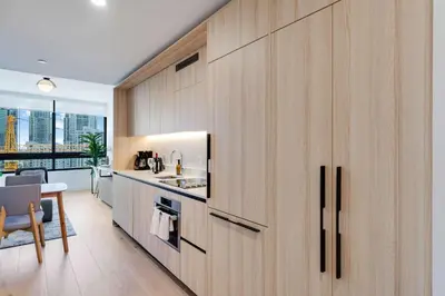 a kitchen with wooden cabinets and a dining room at Sky Corner Residence- Pool Parking Amenities in Miami