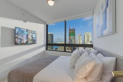 a bedroom with a large white bed with a large window at Miami Skyline 1BR Sleeps 4 with Elite Amenities in Miami