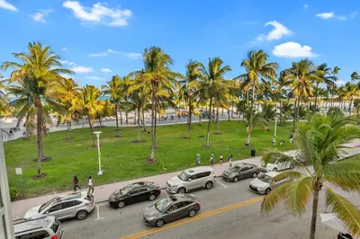 a group of cars parked in a parking lot with palm trees at South Beach, Perfect Oceanfront Apartment, Iconic Art Deco Building, Walk to Everything! in Miami Beach