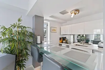a kitchen with white cabinets and a glass counter top at South Beach, Perfect Oceanfront Apartment, Iconic Art Deco Building, Walk to Everything! in Miami Beach