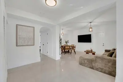 a white living room with a couch and a table at Spacious & Stylish 2BR Retreat near Victoria Park in Fort Lauderdale