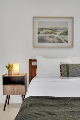 a bedroom with a bed and a nightstand with a picture at Spacious & Stylish 2BR Retreat near Victoria Park in Fort Lauderdale