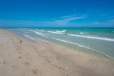 a beach with footprints in the sand and the ocean at Vista Del Mar - by Atlantikos in Hollywood