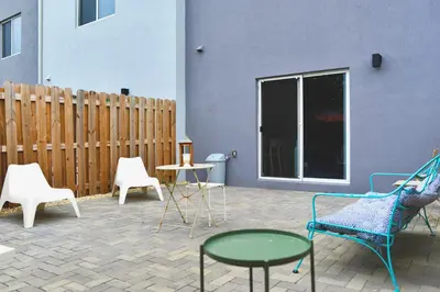 a patio with chairs and tables and a fence at Spacious Entire Duplex for Family Stay in Miami