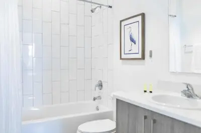 a white bathroom with a toilet and a sink at Spacious Entire Duplex for Family Stay in Miami