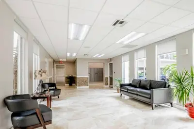 an office lobby with black leather furniture and windows at Le Cartier 207 STR-02440 in Sunny Isles Beach