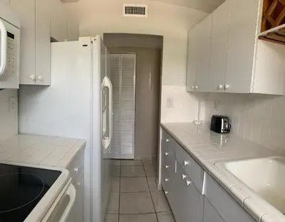a kitchen with white cabinets and a counter top at Le Cartier 207 STR-02440 in Sunny Isles Beach
