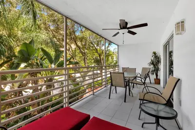 a balcony with a table and chairs and a ceiling fan at Le Frontenac 204 STR-01054 in Sunny Isles Beach