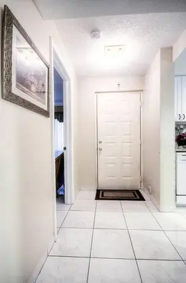 a hallway with a white door and a tile floor at Le Frontenac 205 STR-01057 in Sunny Isles Beach