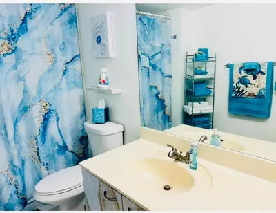 a bathroom with a white sink and a blue marble shower curtain at Le Frontenac in Sunny Isles unit 402 STR-03003 in Sunny Isles Beach