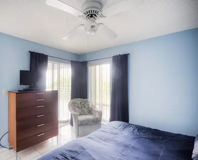 a bedroom with a bed and a dresser and a chair at Le Frontenac 404 STR-02799 in Sunny Isles Beach