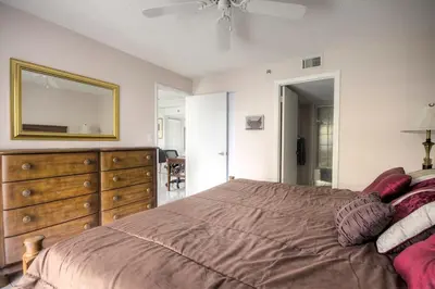 a bedroom with a bed with a dresser and a mirror at Le Frontenac 404 STR-02799 in Sunny Isles Beach
