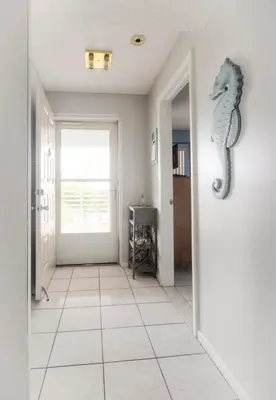a hallway with a door with a seahorse on the wall at Le Frontenac 404 STR-02799 in Sunny Isles Beach