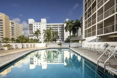 a swimming pool with chairs and a building at Le Frontenac 404 STR-02799 in Sunny Isles Beach