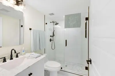 a white bathroom with a shower and a toilet at Le Golden Bay 902 STR-00876 in Sunny Isles Beach