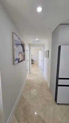 a hallway with white walls and a painting on a wall at Penthouse Condo - Oceanfront - Miami Beach - sleeps 8 in Miami Beach