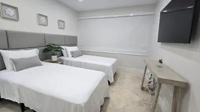 a bedroom with two beds and a flat screen tv at Penthouse Condo - Oceanfront - Miami Beach - sleeps 8 in Miami Beach
