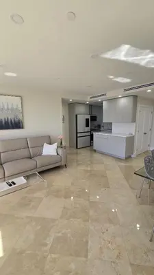 a large living room with a couch and a kitchen at Penthouse Condo - Oceanfront - Miami Beach - sleeps 8 in Miami Beach