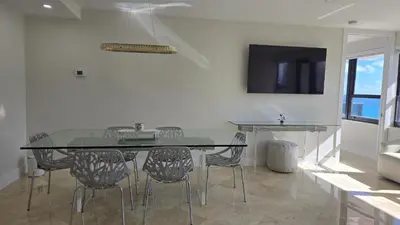 a dining room with a glass table and chairs at Penthouse Condo - Oceanfront - Miami Beach - sleeps 8 in Miami Beach
