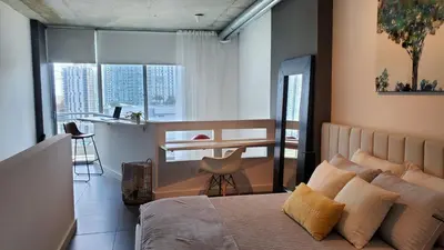 a bedroom with a bed and a desk and a kitchen at Brickell Condo, with FREE parking in Miami