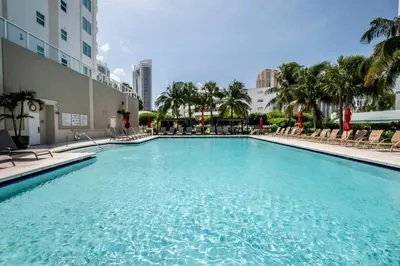 a large swimming pool with chairs and a building at Le Marina Bay 1006 STR-01435 in Sunny Isles Beach