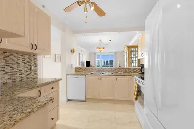 a kitchen with white appliances and a ceiling fan at Le Marina Bay 1106 STR-03006 in Sunny Isles Beach