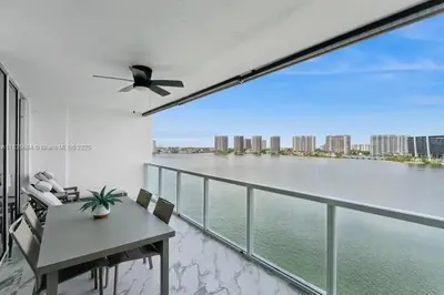 a balcony with a table and a view of the water at Marina Bay Club STR-0 in Sunny Isles Beach