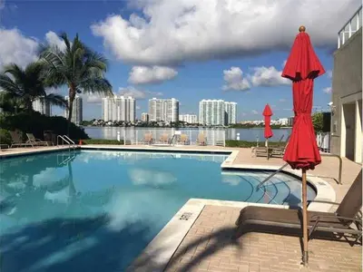 a swimming pool with umbrellas and a view of the city at Le Marina Bay 1109 STR-01972 in Sunny Isles Beach