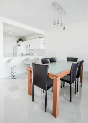 a dining room with a wooden table and black chairs at Le Marina Bay 310 STR-01478 in Sunny Isles Beach