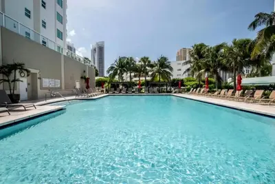 a large swimming pool with chairs and a building at Le Marina Bay 403 STR-01408 in Sunny Isles Beach