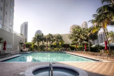 a large swimming pool with palm trees and buildings at Le Marina Bay 403 STR-01408 in Sunny Isles Beach