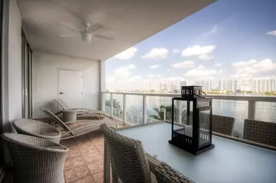 a balcony with a table and chairs and a view of the water at Le Marina Bay 407 STR-01404 in Sunny Isles Beach