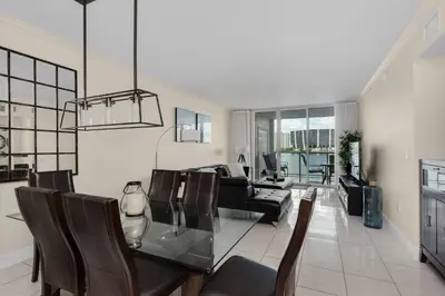 a living room with a glass table and chairs at Le Marina Bay 409 STR -02439 in Sunny Isles Beach